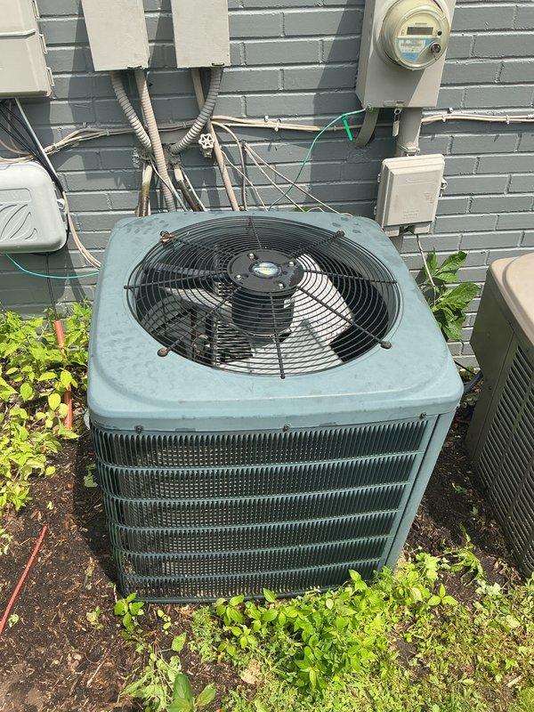 Completed comprehensive Gold AC Inspection on two outdoor air conditioning condenser units located at the property exterior. Performed thorough maintenance on both systems including inspection of condenser coils, fan motors, electrical connections, and refrigerant levels. Both units showed signs of age with weathered cabinets but were found to be in operational condition. Cleaned condenser coils on both units, verified proper airflow through louvers, tested capacitors and contactors, and ensured adequate clearance from surrounding vegetation. Checked electrical meter connections and verified proper voltage supply to both condensers. Inspected fan blades and motor assemblies for wear, lubricated moving components as needed, and confirmed proper fan operation on both units. All safety controls tested and functioning within normal parameters. Recommended ongoing seasonal maintenance to ensure continued reliable operation throughout cooling season.
