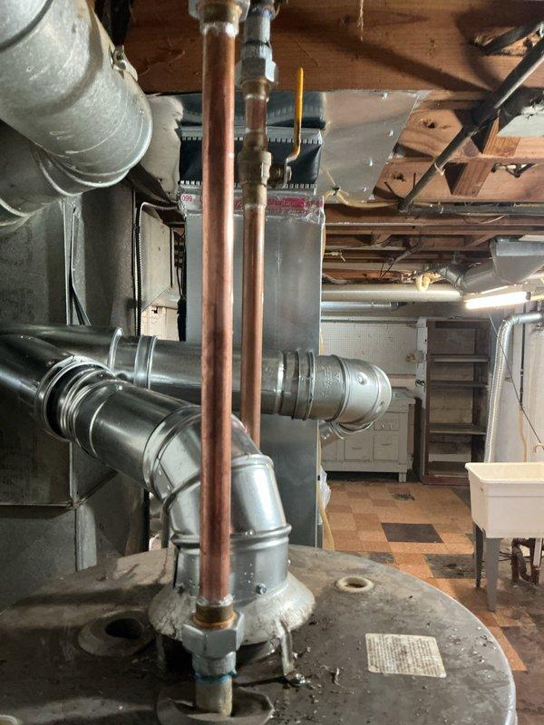 Performed tanked water heater installation in basement mechanical room. Unit was properly positioned, copper supply lines were connected to the top of the tank with shutoff valves installed, and all connections were secured according to plumbing code requirements. Documentation tags were attached to the unit for future reference.