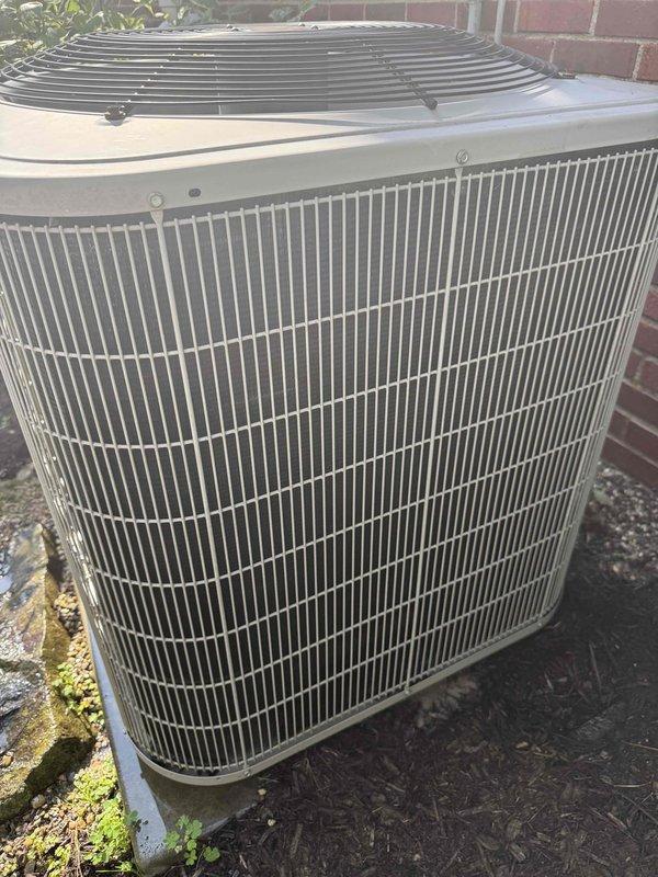 Responded to no cooling complaint on 15-year-old residential air conditioning system located in basement. Upon arrival, confirmed unit was running but producing loud operational noises from outdoor condenser. Performed visual inspection of outdoor condenser unit positioned against exterior brick wall, noting unit appeared structurally intact with no visible external damage to cabinet or coil fins. Conducted electrical diagnostics using digital multimeter to test voltage and amperage at condenser unit. Measured supply voltage and compressor amp draw to determine if compressor was operating within manufacturer specifications. Based on age of equipment and diagnostic findings, identified failing compressor as source of excessive noise and reduced cooling capacity. Advised homeowner of repair options and recommended system replacement due to age and cost-effectiveness of repairs versus new installation. Unit remains operational but requires further action to restore proper cooling function