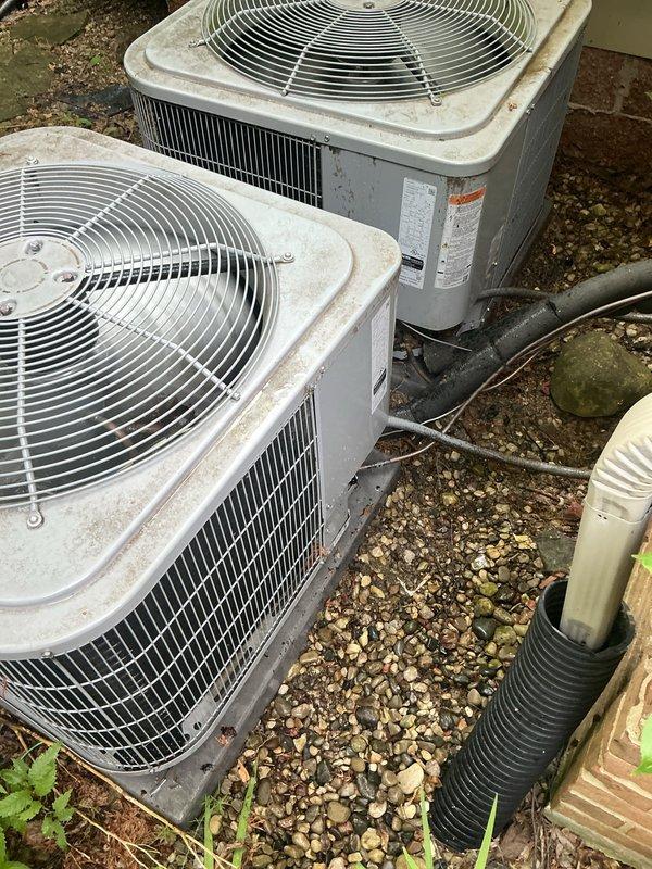 Completed comprehensive Gold AC Inspection on dual 3-year-old residential air conditioning systems with air handler located in basement. Performed multi-point inspection on both outdoor condensing units, including visual assessment of cabinet condition, refrigerant line connections, electrical components, and fan operation. Both units showed normal weathering for age with functional operation confirmed; noted moderate dirt and grime accumulation on exterior casings typical of outdoor exposure. Verified refrigerant lines properly insulated and secured, checked manufacturer labels and specifications, and confirmed adequate clearance around equipment. Systems operating within normal parameters at time of inspection.