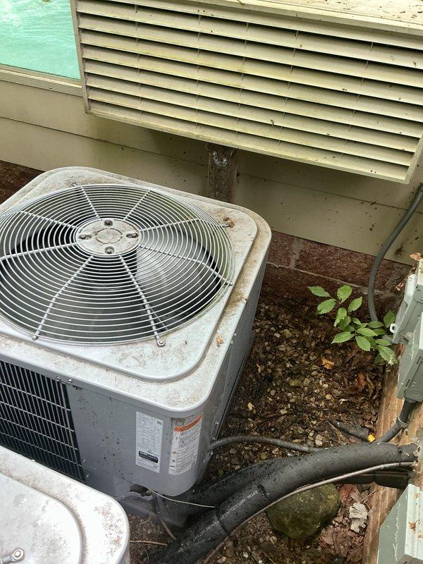 Completed comprehensive Gold AC Inspection on dual 3-year-old residential air conditioning systems with air handler located in basement. Performed multi-point inspection on both outdoor condensing units, including visual assessment of cabinet condition, refrigerant line connections, electrical components, and fan operation. Both units showed normal weathering for age with functional operation confirmed; noted moderate dirt and grime accumulation on exterior casings typical of outdoor exposure. Verified refrigerant lines properly insulated and secured, checked manufacturer labels and specifications, and confirmed adequate clearance around equipment. Systems operating within normal parameters at time of inspection.