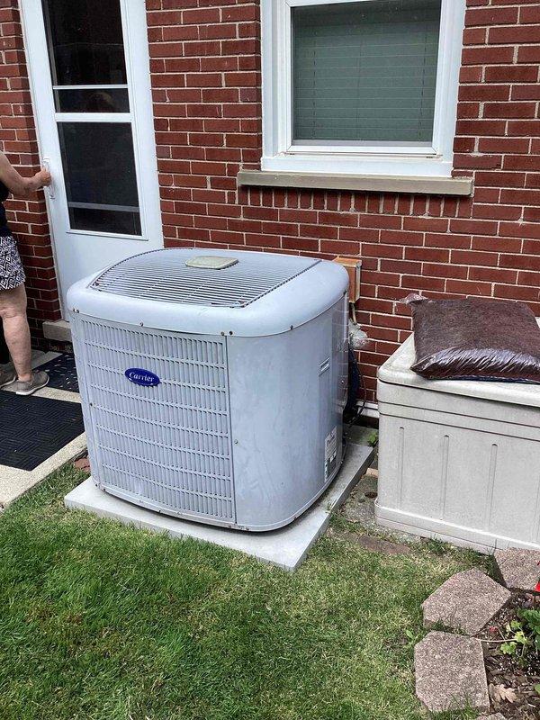 Provided estimate for complete air conditioning system replacement for twenty-year-old equipment. Assessed existing Carrier outdoor condenser unit positioned on concrete pad against exterior brick wall and evaluated indoor air handler located in basement utility area with associated PVC condensate drainage system. Documented current system configuration including water heater proximity and existing electrical connections to prepare comprehensive replacement proposal for aging HVAC equipment that has reached end of expected service life.