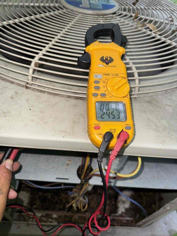 Completed comprehensive Gold AC inspection on 10+ year old single-unit air conditioning system with basement air handler. Performed visual assessment of outdoor condenser unit, noting weathered exterior housing with age-appropriate surface wear and debris accumulation around base on concrete pad. Conducted electrical diagnostics using clamp meter to verify proper amperage draw and voltage readings at condenser unit, confirming system operational parameters within manufacturer specifications. Inspected electrical connections at junction box, documented wire conditions, and verified unit functionality. System currently operating as designed with no immediate service concerns identified during inspection.