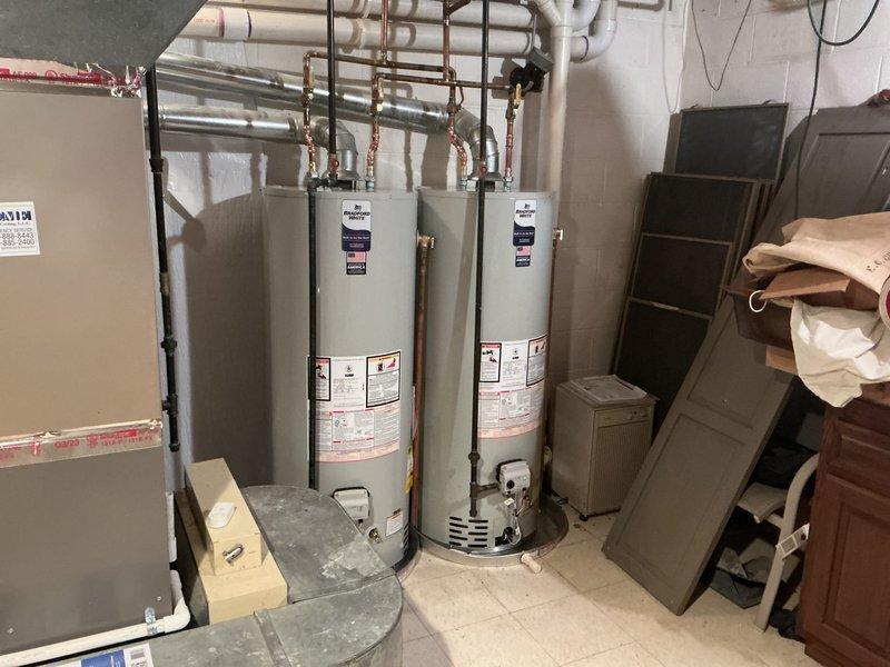 Completed installation of two 50-gallon Bradford White natural gas water heaters (Model RG250T6N) in basement utility area. Installed copper supply piping with brass fittings and valves, connected gas lines to both units, and reconnected all water supply lines to restore domestic hot water service to the residence.