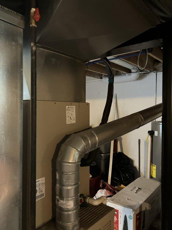 Responded to service call for air conditioning system not producing cold air and failing to maintain temperature. Upon inspection, found 20+ year old AC system with outdoor condenser unit and basement-located air handler had exceeded its operational lifespan. Evaluated complete HVAC system including existing furnace equipment as requested. Documented current equipment configuration with outdoor condensing unit positioned on exterior wall and indoor components located in basement mechanical room with existing ductwork infrastructure. Provided comprehensive replacement estimate for new air conditioning system and discussed furnace replacement options to address aging equipment concerns.