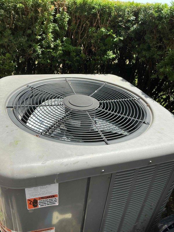 Completed comprehensive Gold AC Inspection on residential property with three HVAC units of varying ages (2011, 2013, and 2020 models). Performed thorough visual assessment of outdoor condenser units, noting weathering consistent with outdoor exposure and minor rust formation on mounting brackets. Inspected fan assemblies, protective grilles, and housing integrity across all units. Evaluated air handler and coil equipment located in basement area. All systems confirmed operational at time of inspection. Documented equipment condition through photographic records showing condenser placement, ventilation clearances, and overall unit status for maintenance history records.