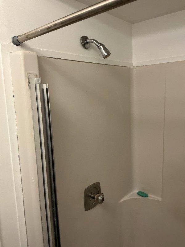 Responded to service call for installation quote of customer-supplied fixtures including sink faucet, dual shower heads, and shower valve assembly. Assessed existing white fiberglass shower enclosure with current chrome fixtures and evaluated mounting points for new hardware. Inspected bathroom vanity area with oval basin and existing faucet configuration to determine installation requirements for customer-provided fixtures. Documented site conditions and fixture specifications through photographs to prepare accurate installation estimate for complete fixture replacement in both shower and sink locations.