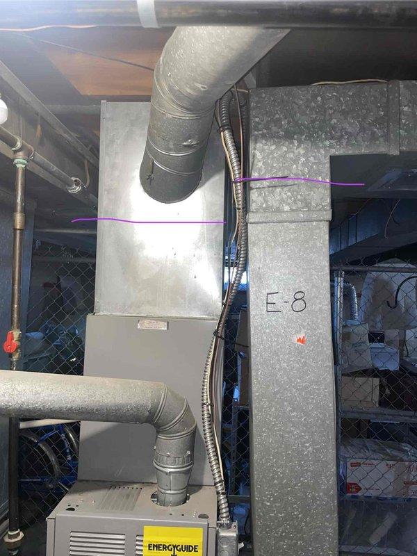 Conducted equipment assessment and provided replacement estimate for non-operational natural gas furnace and air conditioning system located in basement mechanical room, unit E8. Current HVAC equipment exceeded 10+ years of service life and was no longer functioning. Evaluated existing installation including ductwork configuration, electrical connections, condensate drainage, and spatial requirements for new equipment. Documented existing white metal furnace with top-mounted supply plenum, metallic refrigerant line set, and associated gray galvanized ductwork routing through concrete block walls. Reviewed natural gas fuel supply accessibility and electrical service capacity for replacement system specifications.