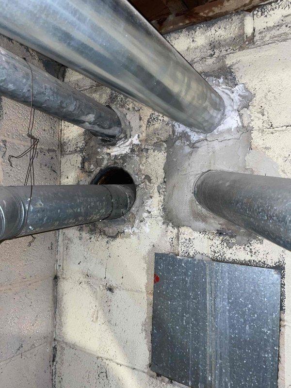 Conducted equipment assessment and provided replacement estimate for non-operational natural gas furnace and air conditioning system located in basement mechanical room, unit E8. Current HVAC equipment exceeded 10+ years of service life and was no longer functioning. Evaluated existing installation including ductwork configuration, electrical connections, condensate drainage, and spatial requirements for new equipment. Documented existing white metal furnace with top-mounted supply plenum, metallic refrigerant line set, and associated gray galvanized ductwork routing through concrete block walls. Reviewed natural gas fuel supply accessibility and electrical service capacity for replacement system specifications.