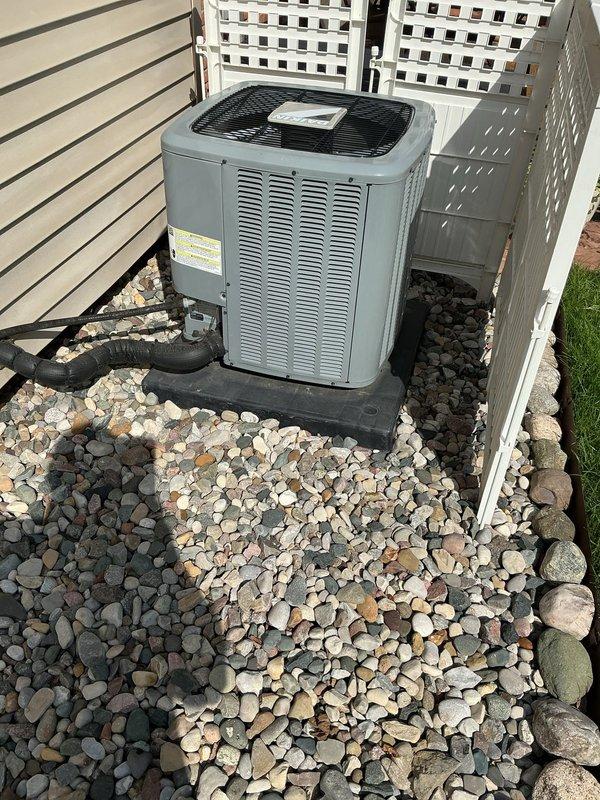 Completed comprehensive Gold AC Inspection on a 3-year-old residential air conditioning system with basement-located air handler. Performed full system evaluation including visual inspection of outdoor condensing unit, verified proper equipment operation and functionality, checked refrigerant levels, inspected electrical connections and components, evaluated airflow and system performance, and assessed overall unit condition. Outdoor unit found properly positioned on protective base pad with adequate clearance and drainage, displaying normal operating characteristics with no immediate service concerns identified. All components functioning within manufacturer specifications at time of inspection.