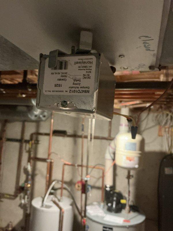 Responded to no cooling complaint on 5-year-old zoned AC system located in basement. Upon inspection, diagnosed failed zone motor actuators preventing proper damper operation in multiple zones. Zone motors were previously ordered under existing purchase order. Replaced defective Honeywell zone actuators on copper piping manifold system, verified proper damper movement, and tested all zones for correct operation. System restored to full cooling capacity with all zones functioning properly.