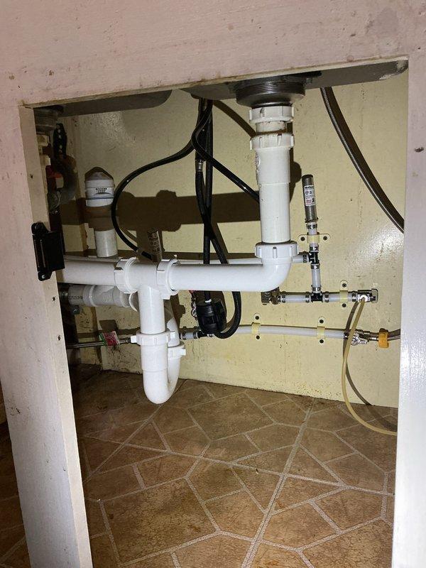 Completed whole house re-pipe installation per approved estimate. Replaced all existing water supply lines throughout the residence with new piping system, including routing lines through attic/crawl space areas and connections to all plumbing fixtures. Under-sink plumbing updated with new PVC drain assemblies, P-trap configuration, and supply line connections to accommodate existing garbage disposal and water filtration system. All connections tested and verified leak-free with proper water pressure and drainage flow throughout the home.