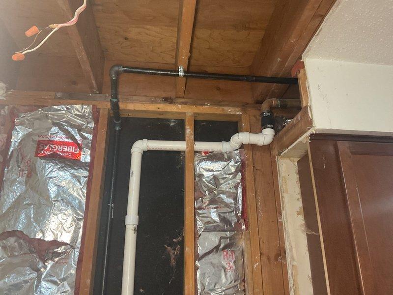 Completed installation and routing of gas lines in utility space with proper connections and fittings. Accessed ceiling cavity to run multiple utility lines including gas piping, coordinating with existing plumbing and electrical systems. Installed black iron gas pipe with approved fittings and connections, ensuring proper support and clearances from other building systems. Secured all piping to structural framing using appropriate brackets and hangers per code requirements. Work included coordination with PVC plumbing lines, PEX water lines, and electrical conduit already present in the space. All gas line connections were properly fitted and prepared for pressure testing and inspection.