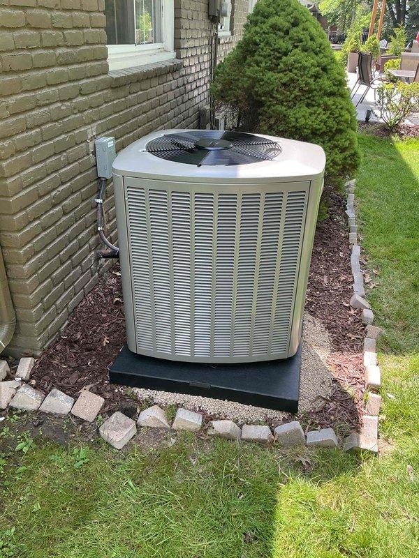 Completed installation of 3.5-ton air conditioning system with evaporator coil at rear of residence. System was properly charged with refrigerant, vacuum tested to manufacturer specifications, and all pressure readings verified within normal operating parameters. Unit positioned on composite pad with proper clearances, electrical disconnect reconnected, and system commissioned with successful startup and operational testing confirmed.