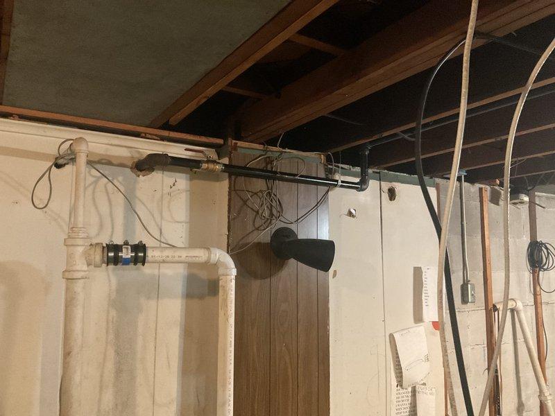 Completed sump pump installation and gas line re-piping in unfinished basement utility area. Installed new PVC drainage piping with appropriate fittings, valves, and connections to ensure proper sump pump discharge. Re-routed gas piping system using code-compliant materials and securing methods along ceiling joists and wall structures to improve safety and functionality of the existing gas distribution system.