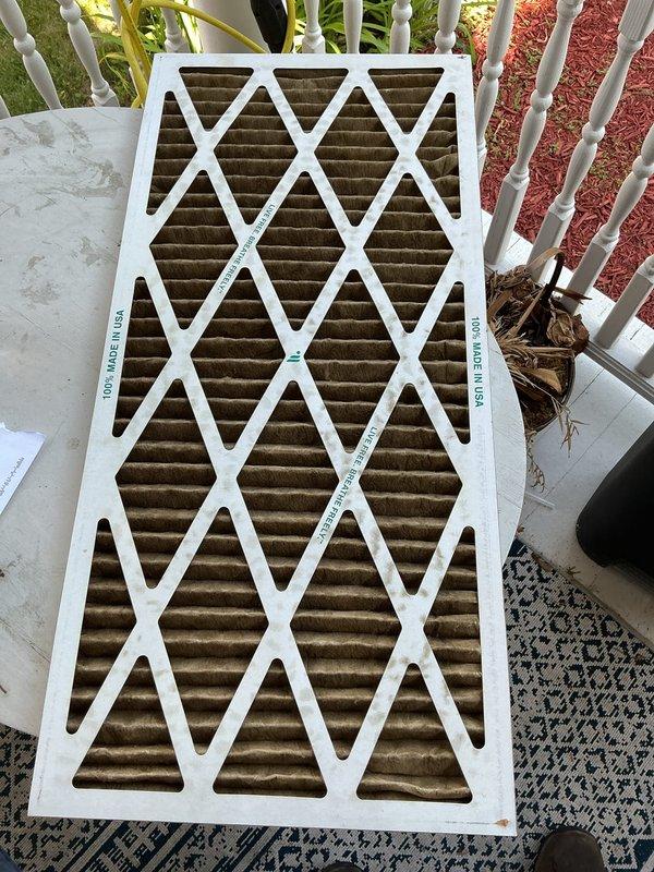 Responded to no-cooling complaint on 5-year-old AC unit located in attic. Found thermostat set to 74°F but indoor temperature reaching only 80°F. Upon inspection, discovered severely clogged air filter with heavy dust and dirt accumulation restricting airflow, and standing water present in condensate drip pan. Replaced contaminated air filter with new filter to restore proper airflow and system performance. Cleared condensate drain line and verified proper drainage from drip pan. System tested and confirmed cooling operation restored to normal parameters with adequate airflow and temperature differential across evaporator coil.