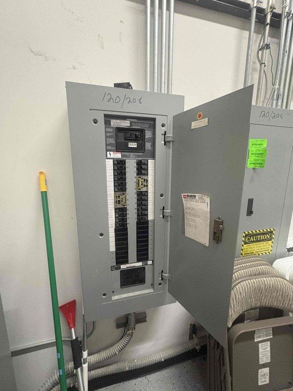 Completed commercial electrical outlet installation and verification in office building. Inspected and documented existing 120/208V electrical panel system with multiple circuit breakers, confirmed proper labeling and safety signage in place. Installed new outlets per specifications and performed comprehensive testing to ensure all receptacles were properly grounded, functioning correctly, and met code requirements throughout the hallway and adjacent office spaces.