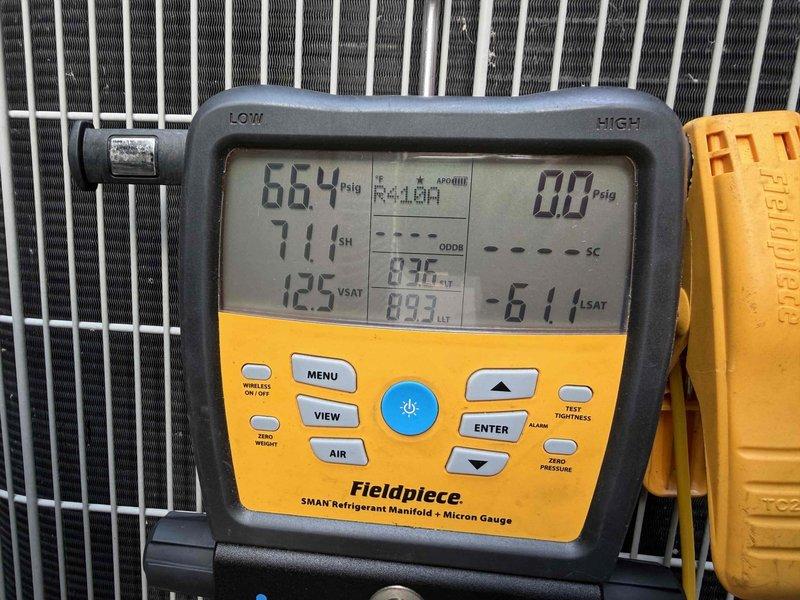 Responded to no cooling complaint on attic-installed mini split system of unknown age. Upon inspection, utilized Fieldpiece SMAN manifold gauge to diagnose R-410A refrigerant system, recording operating pressures of 664 PSIG on high side and 0.0 PSIG on low side, with superheat reading of 71.1°F and saturated suction temperature of 125°F. Diagnostic readings indicated complete loss of refrigerant charge on low pressure side, confirming system was unable to operate due to insufficient refrigerant. Inspected ductwork and condensate drainage system in attic installation, noting dust accumulation on flex ducts and general aging of insulation material. System requires refrigerant leak detection, repair of leak source, evacuation, and proper recharge to restore cooling operation.