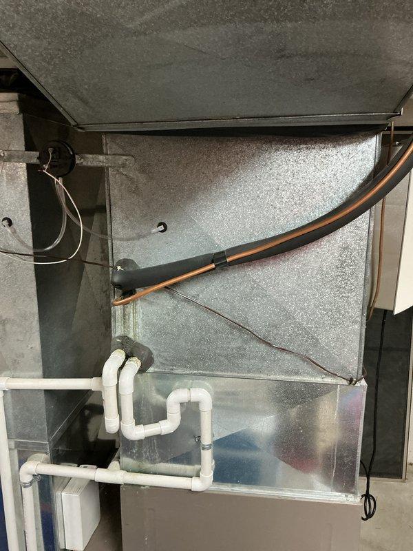 Provided comprehensive replacement estimate for both air conditioning and furnace systems in basement installation. Current 10+ year old York air handler unit is non-operational. Evaluated existing natural gas furnace configuration, ductwork connections, refrigerant lines, and condensate drainage system with white PVC piping. Documented equipment specifications and installation requirements for complete HVAC system replacement.