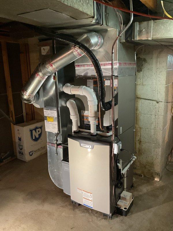 Completed full HVAC system installation including a Lennox 90,000 BTU high-efficiency furnace, 3-ton air conditioning unit with rear discharge configuration, programmable thermostat, and humidifier in basement mechanical room. Installed all necessary PVC condensate drain lines and combustion air intake/exhaust venting, connected refrigerant lines and electrical components, and integrated system with existing ductwork. Reconnected all utilities, verified proper operation of all equipment, and submitted permit applications for mechanical and electrical work to facilitate consumer energy rebate processing.