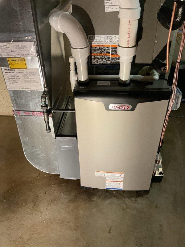 Completed full HVAC system installation including a Lennox 90,000 BTU high-efficiency furnace, 3-ton air conditioning unit with rear discharge configuration, programmable thermostat, and humidifier in basement mechanical room. Installed all necessary PVC condensate drain lines and combustion air intake/exhaust venting, connected refrigerant lines and electrical components, and integrated system with existing ductwork. Reconnected all utilities, verified proper operation of all equipment, and submitted permit applications for mechanical and electrical work to facilitate consumer energy rebate processing.