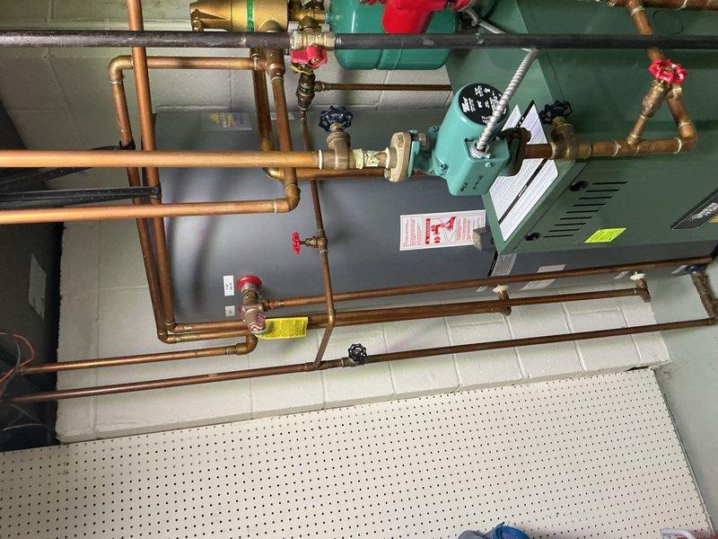 Completed comprehensive Gold AC inspection on 7-year-old Bryant air conditioning system with basement-located air handler. Performed full system evaluation including outdoor condenser unit examination, verified proper airflow through coil, checked refrigerant pressures and temperatures, inspected electrical connections and components, tested capacitor values, and evaluated overall system operation. Noted condenser unit surrounded by vegetation requiring clearance maintenance for optimal airflow and efficiency. All mechanical components, copper piping connections, and hydronic system integration operating within normal parameters at time of inspection.