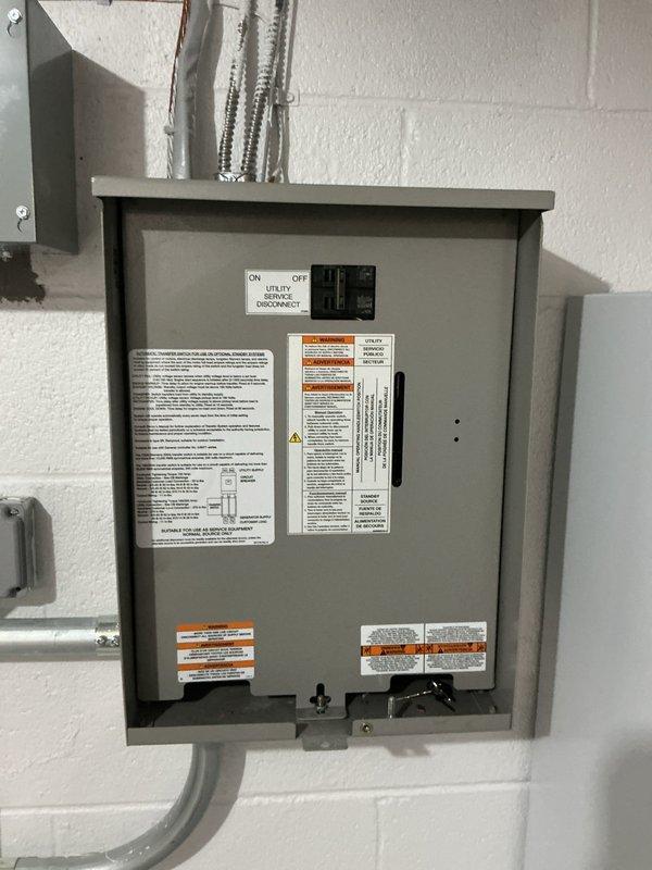Responded to no-power condition affecting generator-supplied circuits following utility power restoration. Inspected Generac 24KW standby generator system including transfer switch, control module, and electrical distribution panel. Verified utility disconnect switch position, examined transfer switch operation and control board LED indicators, and confirmed proper wiring connections at bus bars and circuit breakers. System evaluated and operational status documented with photographic records of transfer switch interior components and external disconnect panel configuration.