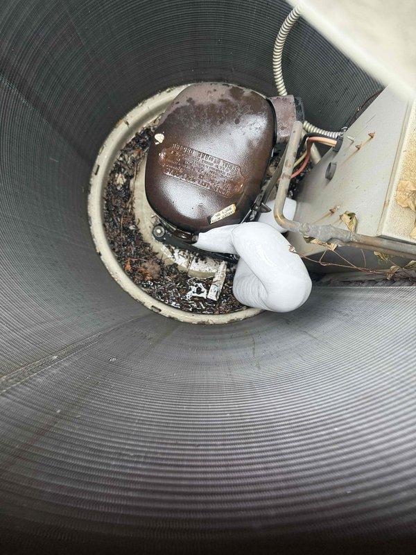 Responded to service call for water leaking from basement air conditioning unit onto floor instead of draining properly. Upon arrival, confirmed AC system was operational and cooling effectively, with continuous water stream present rather than proper condensate drainage. Inspected condensate drainage system including primary drain line, secondary overflow provisions, and exterior discharge points.

Located obstruction in primary condensate drain line preventing proper water flow to designated drain receptacle. Cleared blockage from drain line using appropriate tools and techniques to restore full drainage capacity. Verified condensate was flowing freely through drain system to exterior discharge point shown in photos, where PVC condensate line connects to exterior junction near ground level with proper air gap and drainage pathway.

Inspected sump pump system in basement area, which appeared functional with float switch mechanism operational. Noted sump basin contained normal sediment