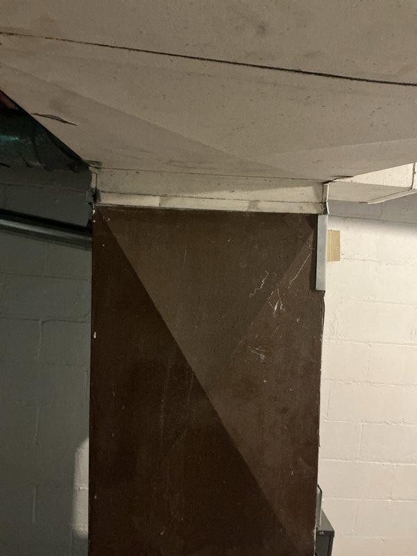 Conducted site assessment for new central air conditioning system installation at property with no existing AC equipment. Evaluated interior thermostat location and documented current heating system controls, noting existing smart thermostat set at 56°F heat setpoint with indoor temperature reading 73°F. Inspected basement utility area with painted concrete block walls to determine optimal routing for refrigerant lines, condensate drainage, and electrical connections. Discussed outdoor condenser unit placement options with property owner to determine most suitable location for equipment installation. Documented wall conditions near existing HVAC controls and assessed structural considerations for new system integration with current heating infrastructure.