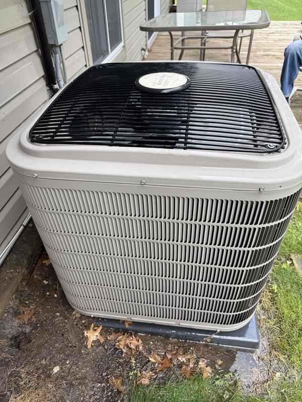 Responded to service call for outdoor air conditioning condenser unit reporting slight operational noise. Inspected condenser unit located on exterior concrete pad, verified unit operation and assessed mechanical components for abnormal sounds. Examined condenser fan motor, compressor, and associated hardware for loose components or wear indicators. Documented equipment condition with photos showing outdoor condenser unit and indoor furnace plumbing connections in main level laundry room. Unit operational at time of inspection with age-related wear consistent with equipment over 10 years old.