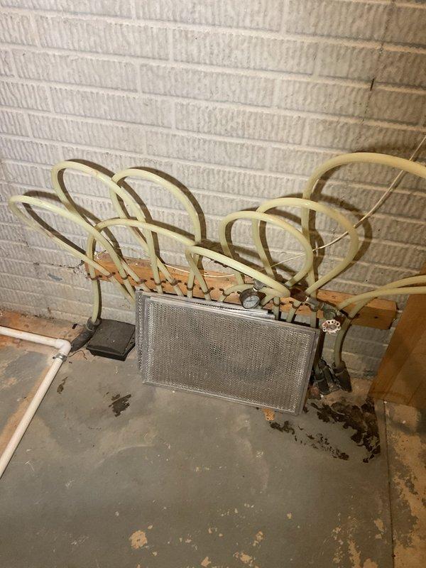 Assessed existing radiant floor heating system that was previously installed but never connected or commissioned. Inspected system components and determined requirements for connecting to existing water heater located in commercial space. Identified need for thermostat installation and associated connectors to complete the system hookup. Documented current water treatment equipment including water softener and filtration system, along with existing HVAC evaporator coil assembly with copper refrigerant lines and heat exchanger. Evaluated plumbing infrastructure and provided estimate for necessary connections, controls, and startup procedures to make radiant heating system operational.