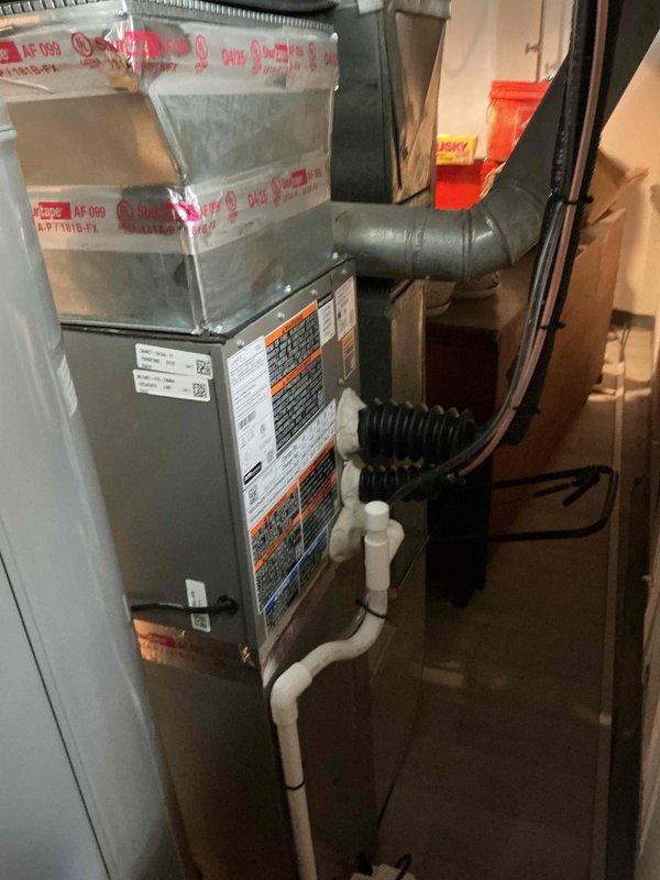 Completed installation of a 2-ton air conditioning system with matching evaporator coil in residential basement utility area. Installed new air handler unit with proper ductwork connections, condensate drain lines using white PVC piping, and established new dedicated electrical circuit to code. Coordinated mechanical and electrical permits, positioned outdoor condenser unit in rear yard, and ensured all components are operational and meet manufacturer specifications.