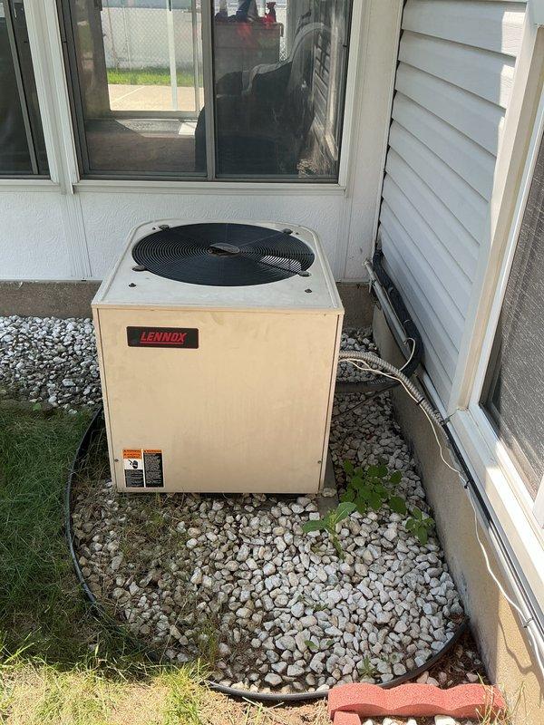 Conducted on-site evaluation for complete air conditioning system replacement of 30-year-old outdoor Lennox condenser unit. System had been previously flagged for replacement during summer inspection due to age and declining efficiency. Documented existing equipment configuration including outdoor condensing unit positioned on gravel pad adjacent to residence with refrigerant lines running along exterior wall, and indoor air handler/furnace unit located in basement utility area with associated ductwork and PVC condensate drainage. Photographed current system components and installation layout to provide comprehensive visual documentation for replacement proposal. Assessed electrical service connections, refrigerant line routing, condensate drainage pathways, and clearance requirements for new equipment installation. Evaluated existing ductwork connections and determined compatibility requirements for new system integration. Provided detailed replacement estimate including equipment spe