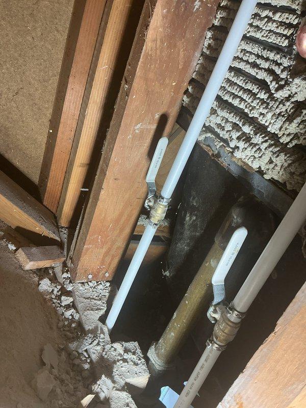 Responded to plumbing service call for bathtub faucet replacement. Accessed existing plumbing infrastructure through attic crawl space above bathroom. Removed dated chrome tub spout and faucet assembly from peach-tiled bathroom wall. Installed new PVC supply lines with brass shut-off valves in attic space to provide proper water control and meet current code requirements. Connected new fixtures to updated supply lines, ensuring proper water flow and pressure. Tested installation for leaks and verified proper drainage through existing tub drain assembly. All connections secured and system restored to full operation.