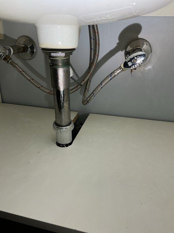 Responded to upstairs bathroom plumbing emergency involving a compromised drain pipe that had been actively leaking for six days. Upon inspection, identified a hole in the metallic drain pipe assembly near the ceiling-wall junction, causing water damage and requiring immediate repair. Removed the damaged section of pipe, installed replacement pipe segment with proper sealing and securing hardware including metal clamp fasteners, and verified all connections were watertight. Tested the repaired drain system under normal flow conditions to confirm leak was fully resolved and no additional moisture intrusion was present.