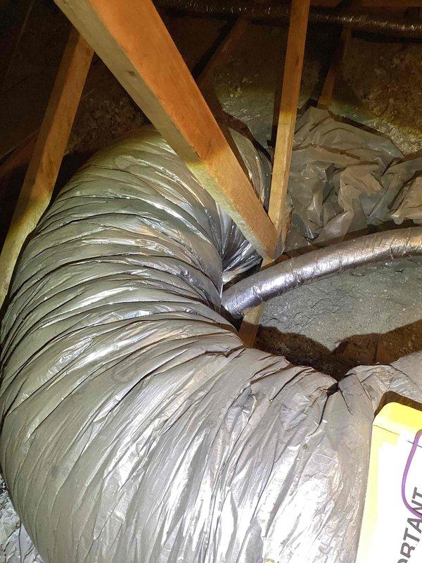 Responded to service call for 20-year-old R22 air conditioning system not cooling adequately, with unit located beside garage. Upon inspection, found system was empty of refrigerant. Assessed existing ductwork system in attic space, including metal supply plenum and flexible duct runs with reflective insulation showing age-related wear. Due to depleted R22 refrigerant, age of equipment, and obsolete refrigerant type, provided comprehensive estimate for complete HVAC system replacement.