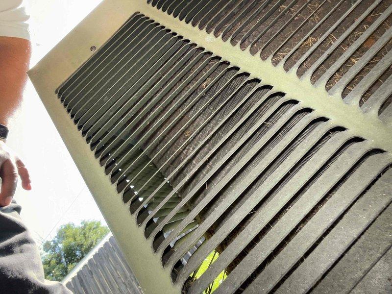 Responded to service call for AC unit running at furnace but not cooling home. Upon inspection, found outdoor condenser unit with heavily soiled coil fins restricting airflow, with accumulated dirt, debris, and organic matter lodged between fins. Cleaned condenser coils to restore proper heat exchange and airflow. Unit tested and confirmed operational with adequate cooling restored to residence.