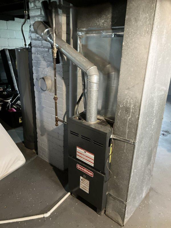 Responded to service call for non-operational central air conditioning system. Upon inspection, discovered outdoor condensing unit with R22 refrigerant had completely depleted refrigerant charge, rendering system inoperable. Assessed existing Goodman furnace and AC system configuration in basement mechanical room and exterior location. Provided comprehensive replacement estimate for new HVAC system due to obsolete R22 refrigerant and complete loss of cooling capacity.