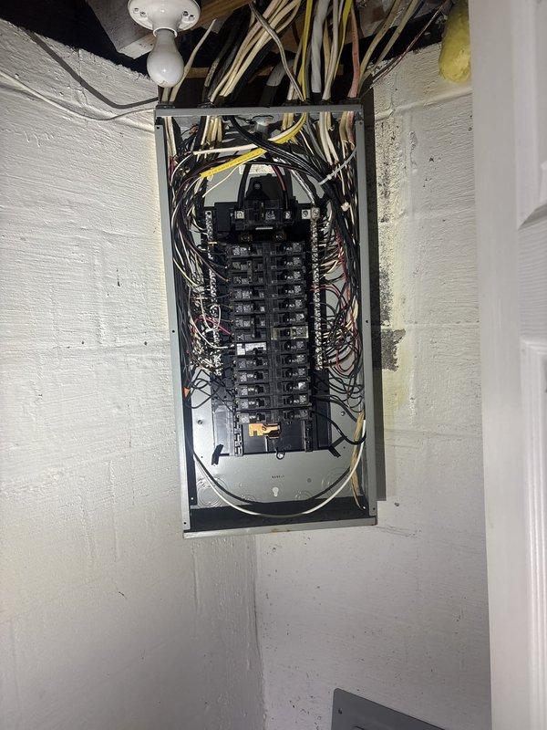 Responded to service call for damaged electrical panel box requiring repair or replacement. Upon inspection, found electrical panel housing with compromised mounting or structural damage. Assessed panel condition, verified circuit breaker functionality, and examined wire connections for safety concerns. Secured panel box mounting to wall, ensured proper grounding and bonding connections, and verified all circuit breakers were properly seated and operational. Confirmed all electrical wiring entering panel from ceiling joists maintained proper strain relief and code-compliant installation. Tested panel integrity and verified safe operation of electrical system upon completion.