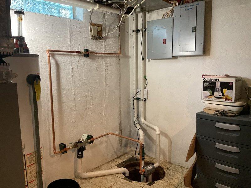Installed battery backup system for existing sump pump to provide emergency operation during power outages. Performed backflow prevention device testing on copper piping system with test cocks to ensure proper operation and compliance with local plumbing codes. Completed all work in accordance with permit requirements, verifying proper installation of backflow preventer assembly with isolation valves and test ports. System tested and confirmed operational.