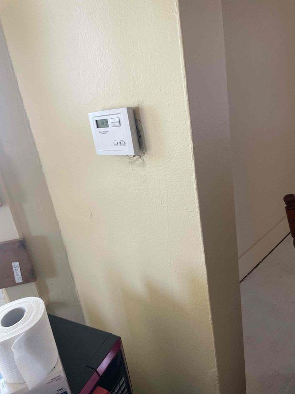 Conducted on-site assessment for central air conditioning system replacement. Evaluated existing HVAC infrastructure including main supply plenum, ductwork configuration, and current thermostat control system. Documented equipment location in mechanical room showing aged galvanized metal ductwork with dust accumulation and existing ceiling penetrations. Photographed thermostat mounting location and surrounding wall conditions to determine compatibility requirements for new system installation. Provided comprehensive estimate for complete central air conditioning system replacement based on existing duct infrastructure and space requirements.