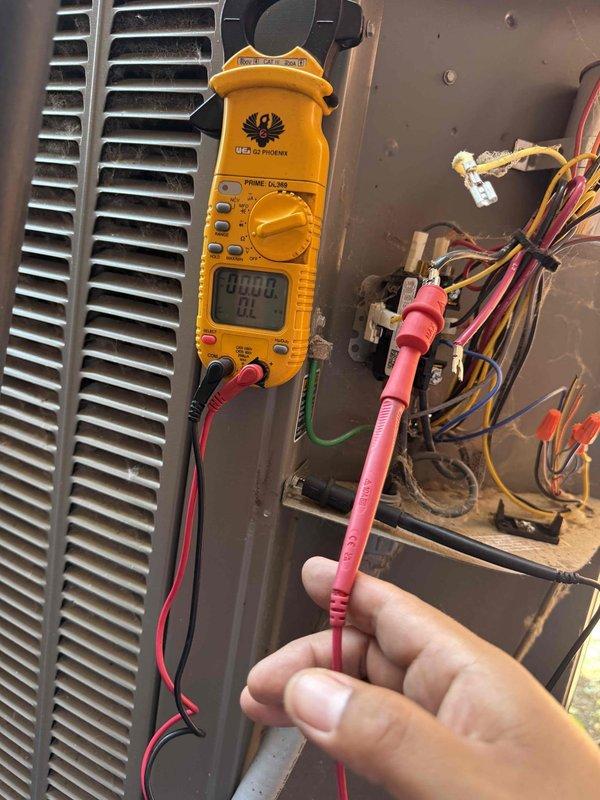 Responded to no cooling complaint on 14-year-old AC unit located in basement that was completely shut off and would not restart. Upon arrival, performed electrical diagnostics using clamp meter to test for power and continuity at the unit. Inspection revealed unit was not receiving power or responding to thermostat calls. Checked electrical connections, terminals, and wiring at the air handler, finding loose or failed connections preventing unit operation. Tested voltage at multiple points in the electrical circuit to isolate the failure. Observed condenser coils showed moderate dirt and debris accumulation, which would impact efficiency once unit was restored to operation. Secured all electrical connections, restored power to the system, and verified unit responded properly to thermostat commands. Cycled system through complete startup sequence to confirm proper operation of blower motor, compressor engagement, and cooling cycle initiation. Unit returned to normal cooling operation wi