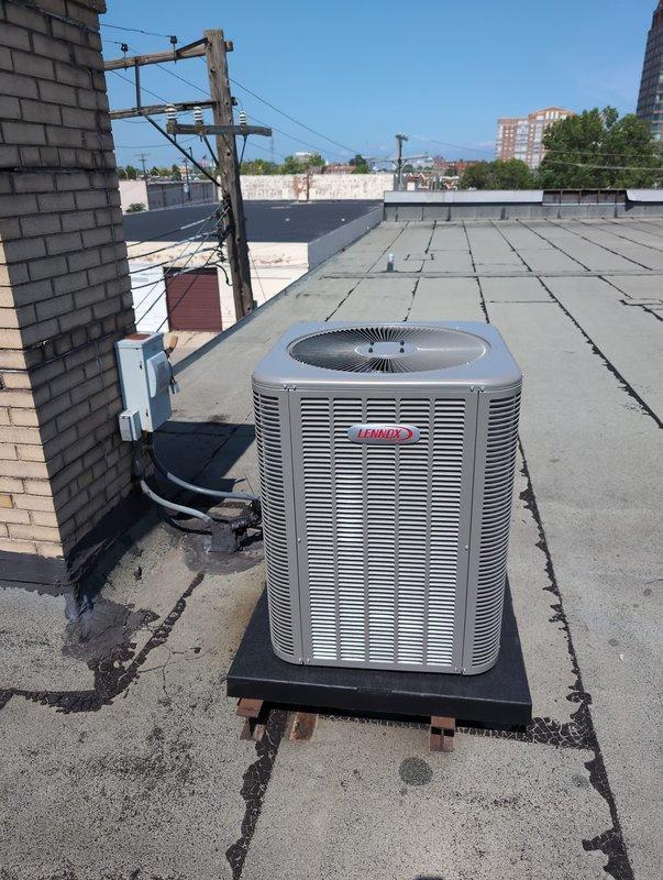 Completed commercial HVAC system replacement involving rooftop condenser installation and first-floor air handler changeout. Accessed roof via second-floor restroom, hoisted equipment to rooftop, and removed existing Lennox upflow air handler. Installed new upflow unit positioned 8" lower than original, requiring custom sheet metal collar fabrication to accommodate height differential. Set new Lennox condenser on rooftop mounting pad with proper support blocking, flushed existing refrigerant line set to ensure system cleanliness, and connected all refrigerant lines. Retained existing thermostat and electrical disconnect per customer request. Verified all electrical connections, tested system operation, and confirmed proper airflow and refrigerant charge levels.