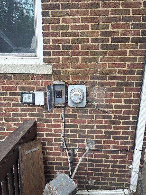 Reinstalled electrical circuit box on exterior brick wall following storm damage. Ran new conduit lines from circuit box to service connector using flexible metal armored cable, securing all connections per code requirements. Restored proper electrical service configuration with all components properly mounted and grounded.