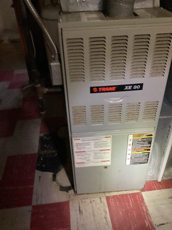 Conducted full system evaluation for complete HVAC replacement at residential property. Assessed existing Trane XE 80 furnace in basement and outdoor condensing unit mounted on exterior brick wall near electrical meter, documenting current equipment condition and installation specifications through detailed photography. Provided comprehensive estimate for new system installation to replace aging equipment.