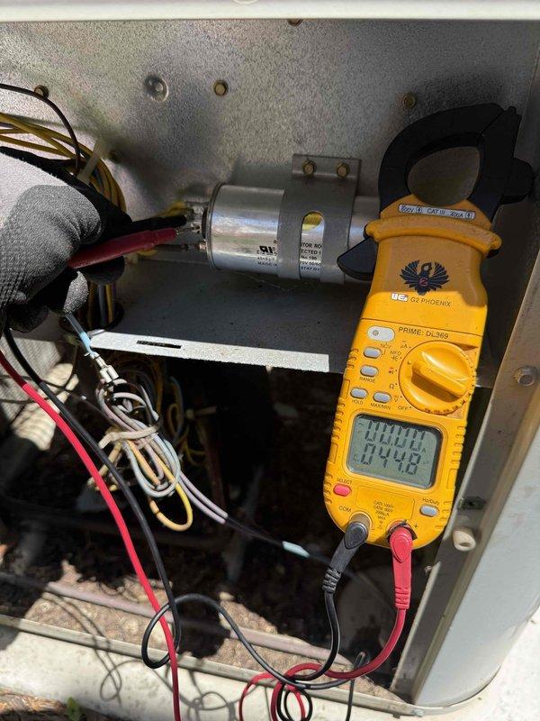 Completed comprehensive Gold AC Inspection on 20-year-old residential air conditioning system. Performed electrical diagnostics using clamp meter to verify proper amperage draw and system performance. Inspected condenser unit exterior components including fan guard, verified Puron refrigerant specifications, and examined all electrical connections within control panel including capacitor and wiring. Unit operating within normal parameters with no issues identified during routine maintenance inspection.