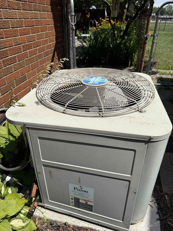 Completed comprehensive Gold AC Inspection on 20-year-old residential air conditioning system. Performed electrical diagnostics using clamp meter to verify proper amperage draw and system performance. Inspected condenser unit exterior components including fan guard, verified Puron refrigerant specifications, and examined all electrical connections within control panel including capacitor and wiring. Unit operating within normal parameters with no issues identified during routine maintenance inspection.