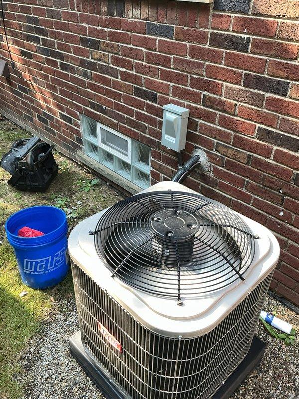 Completed comprehensive Gold AC inspection on a 4-year-old residential air conditioning system with outdoor condensing unit and basement-located air handler. Performed thorough visual assessment of exterior condenser unit positioned on concrete pad, verifying proper installation, clearances, and physical condition of cabinet and coil fins. Inspected electrical disconnect box and associated conduit connections mounted on exterior wall for secure mounting and proper weatherproofing. Evaluated refrigerant lines, electrical connections, and overall system operation. Unit found to be in good working condition with no immediate service concerns identified. All components inspected and verified operational per manufacturer specifications and industry standards.