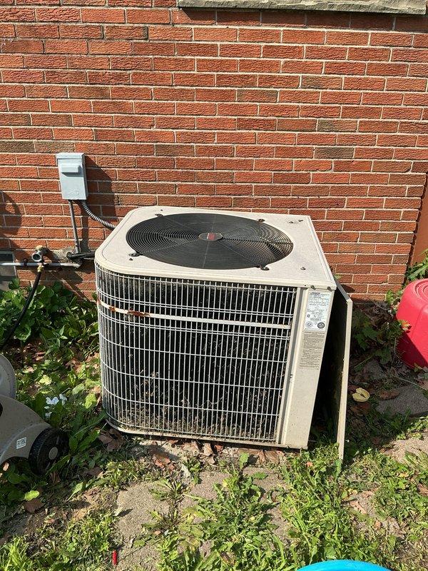 Conducted on-site evaluation of aging 2-ton air conditioning unit positioned against exterior brick wall. Unit exhibited significant weathering and deterioration consistent with end-of-service-life condition. Assessed existing outdoor condenser specifications and electrical disconnect configuration. Photographed current installation including unit positioning, electrical connections, and surrounding clearances. Evaluated interior Goodman furnace system to determine compatibility requirements for replacement outdoor unit. Customer specifically requested pricing options for economical replacement models without heat pump functionality. Provided recommendations for standard efficiency 2-ton air conditioning systems suitable for direct replacement of existing equipment.