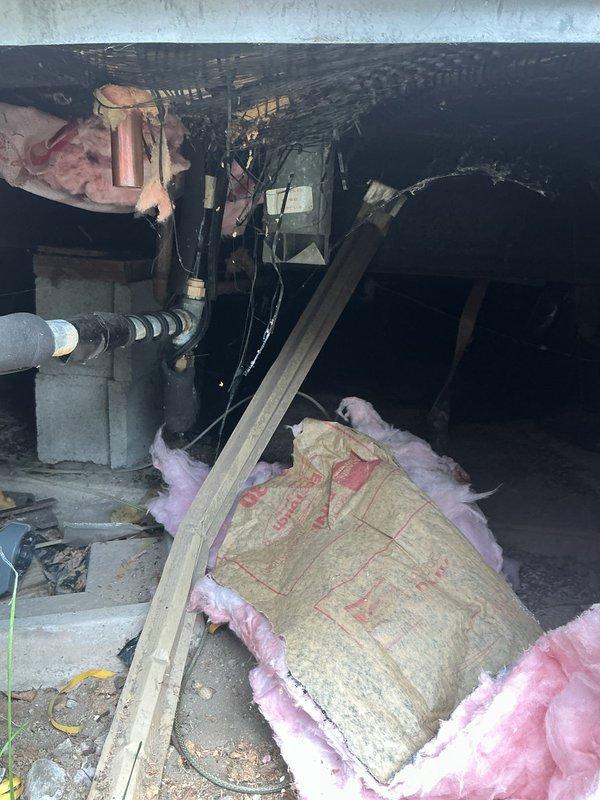 Responded to service call for mobile home water heater with pilot light failure. Upon inspection, confirmed concerns raised by utility company regarding improper installation and ventilation configuration in crawl space. Documented existing conditions showing water heater installation beneath structure with questionable venting arrangement and accessibility issues. Photographed exterior property access point and crawl space area revealing substandard installation practices including compromised insulation, inadequate clearances, and ventilation components not meeting mobile home water heater code requirements. Flagged unit for immediate attention due to safety concerns and recommended consultation with management regarding installation deficiencies and potential recall status.